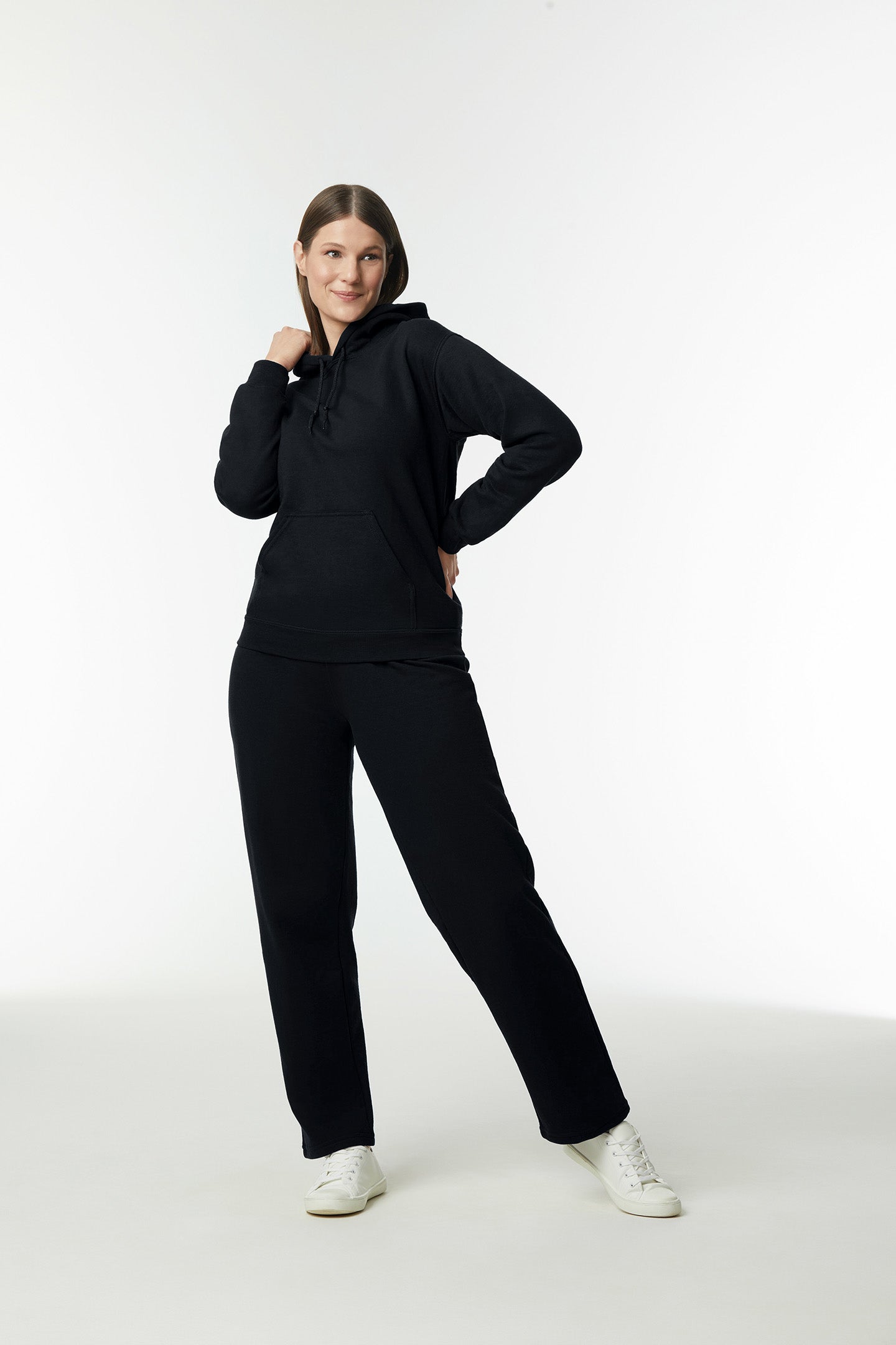 Hooded Sweatshirt | Heavy Blend black unisex hoodie with double-lined hood and pouch pocket worn by smiling woman.