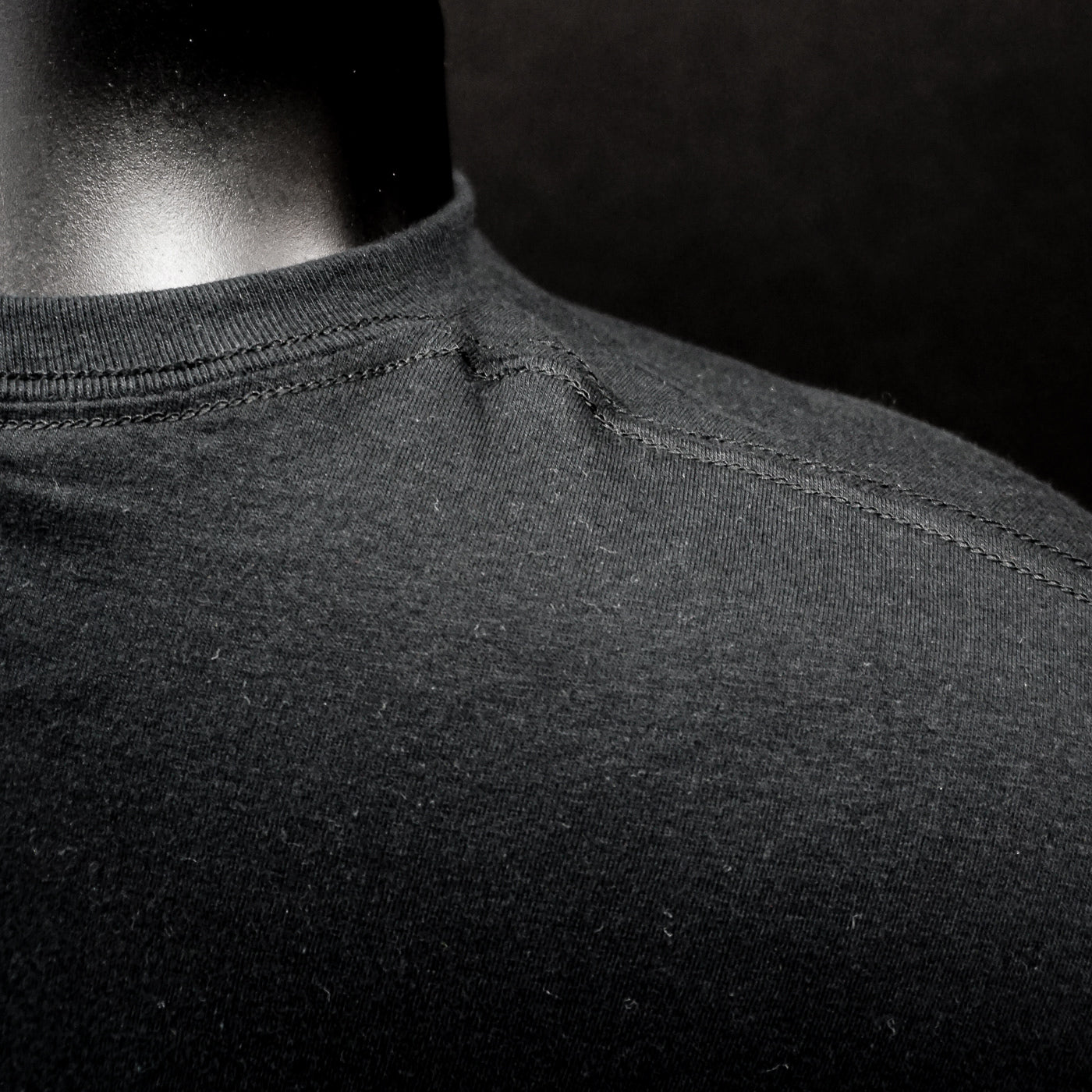 Close-up of black fabric stitching on Dark Throne T-Shirt, Lord of the Underworld with a rib collar and smooth texture.