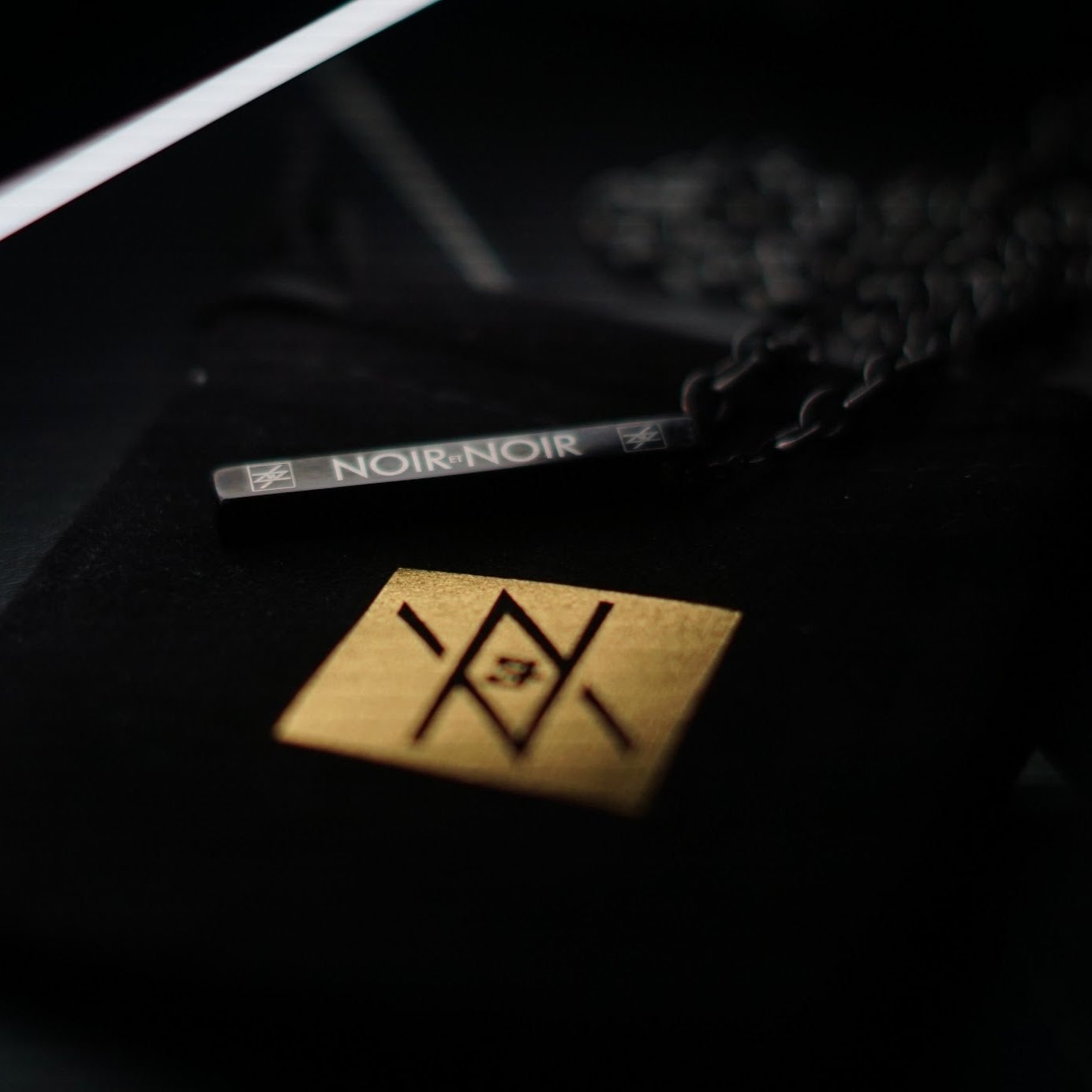 Custom Laser Engraved anti stress necklace with black stainless steel bar pendant engraved Noir et Noir logo.