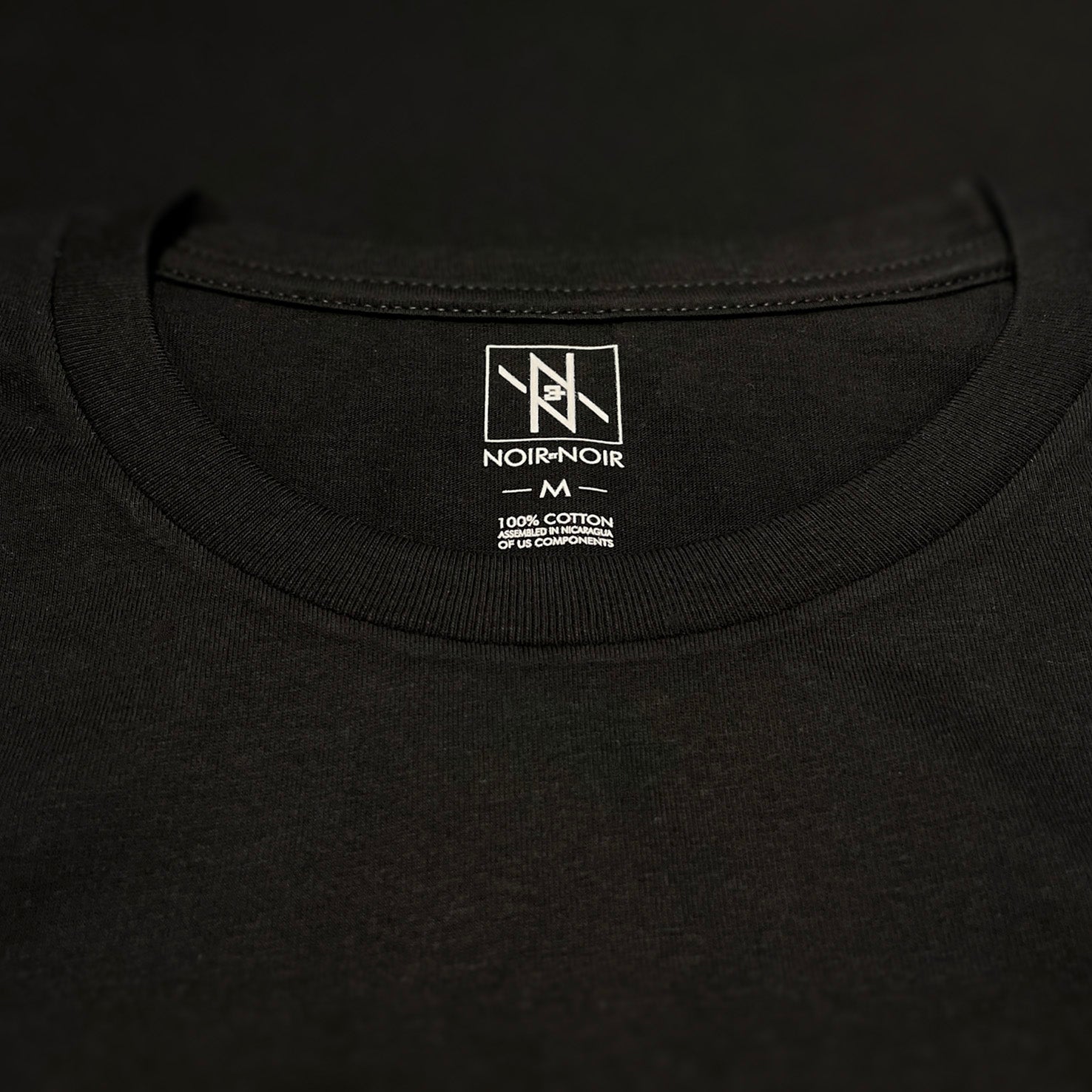 Close-up of the Noir et Noir branding label and collar detail on the Octopus unisex T-shirt, showcasing premium craftsmanship and attention to detail. Part of the elegant Design Collection