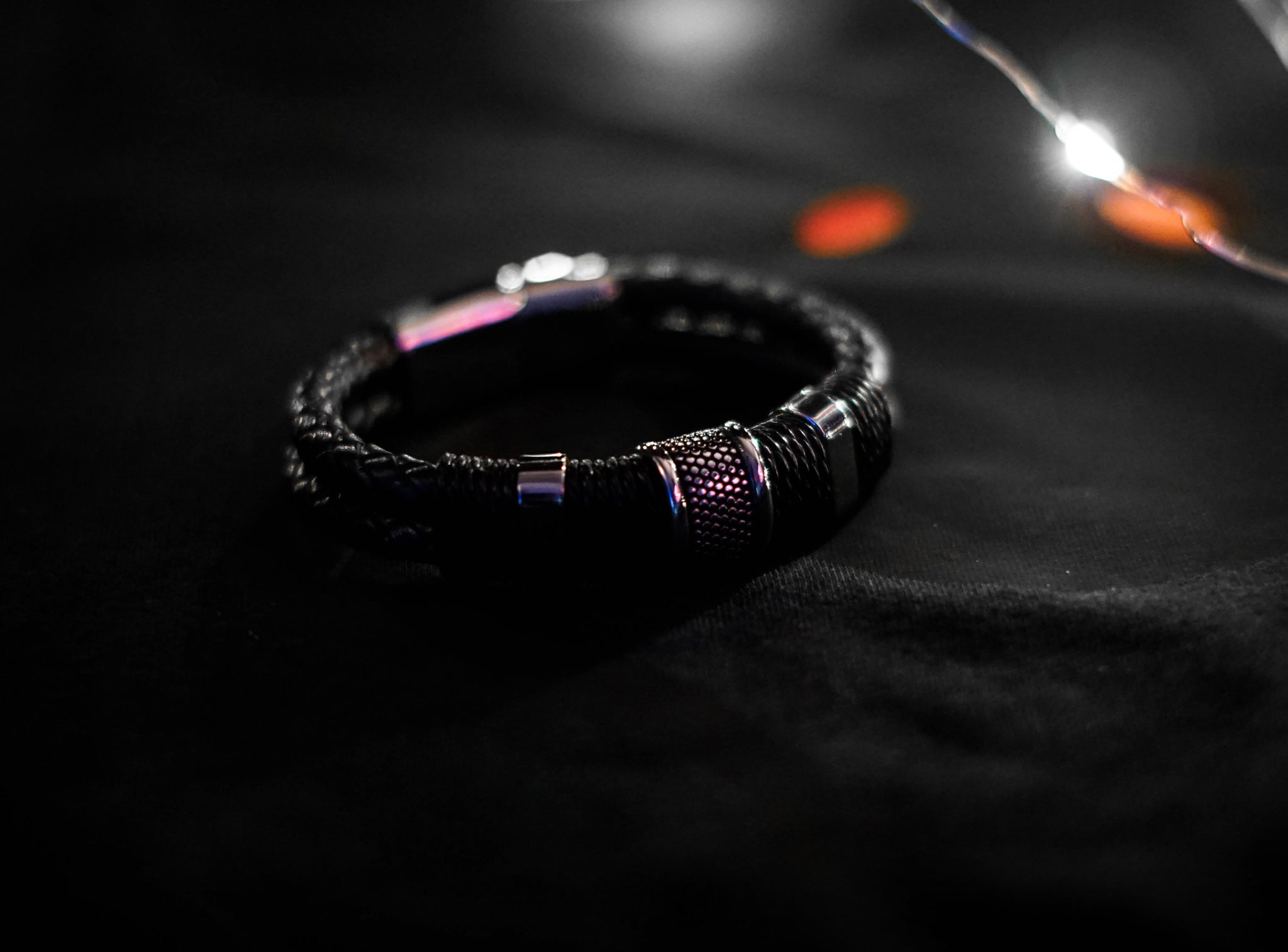 Black Woven Leather Bracelet with woven leather rows, stainless steel beads, twine details, and magnetic lobster clasp closure.