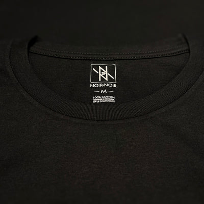Close-up of the Noir et Noir branding label and collar detail on the Moose unisex T-shirt, showcasing premium craftsmanship and attention to detail. Part of the elegant Design Collection.
