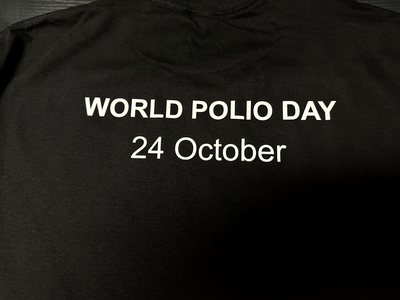 World Polio Day T-shirt in black with white text reading "WORLD POLIO DAY 24 October" celebrating polio survivors.