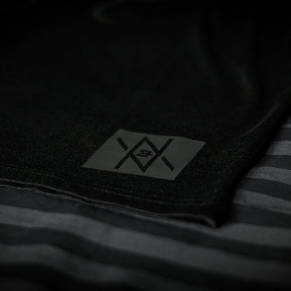 Detailed view of the Noir et Noir GOAT unisex T-shirt's black-on-black logo, highlighting the precision and quality of the matte print. Essential for a modern, minimalist wardrobe. Featured in the Design Collection.
