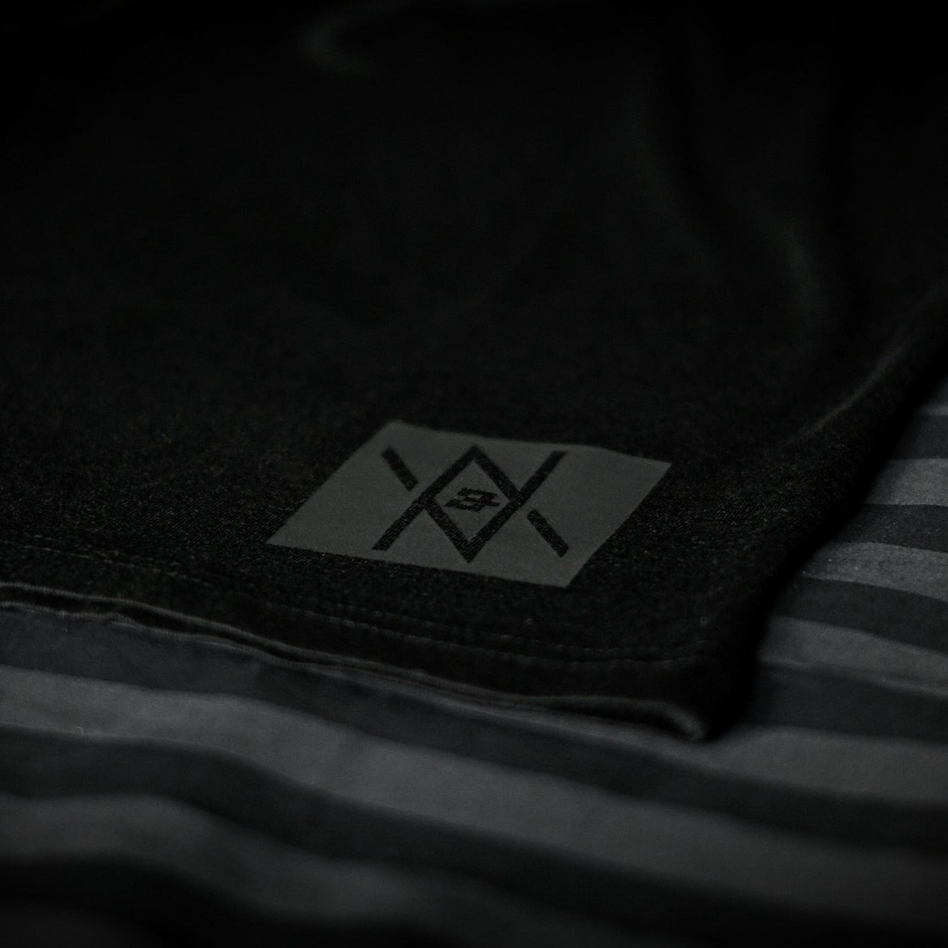 Detailed view of the Noir et Noir Moose unisex T-shirt's black-on-black logo, highlighting the precision and quality of the print. Essential for a modern, minimalist wardrobe. Featured in the Design Collection