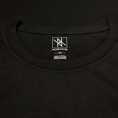 Close-up of the Noir et Noir branding label and collar detail on the GOAT unisex T-shirt, showcasing premium craftsmanship and attention to detail. Part of the elegant Design Collection